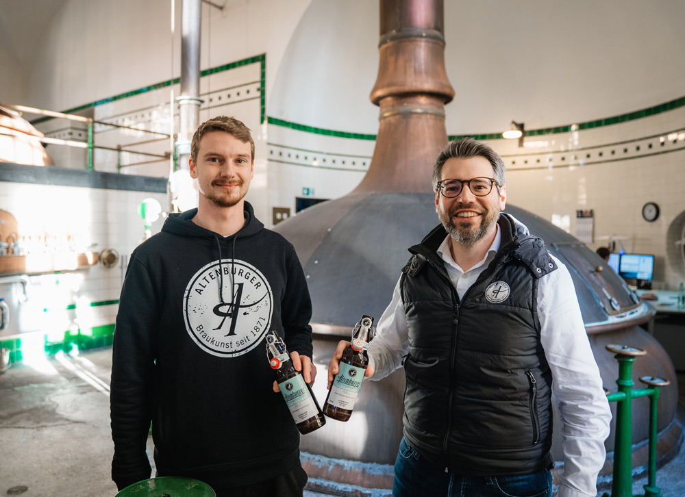 Braumeister Linus Kästner (links) und Geschäfstführer Bastian Leikeim (rechts) beim Anstoßen mit dem neuen naturbelassenen Altenburger Alkoholfrei Hell im Sudhaus der Altenburger Brauerei. (Bildquelle: Altenburger Brauerei GmbH) Altenbur Alkoholfrei
